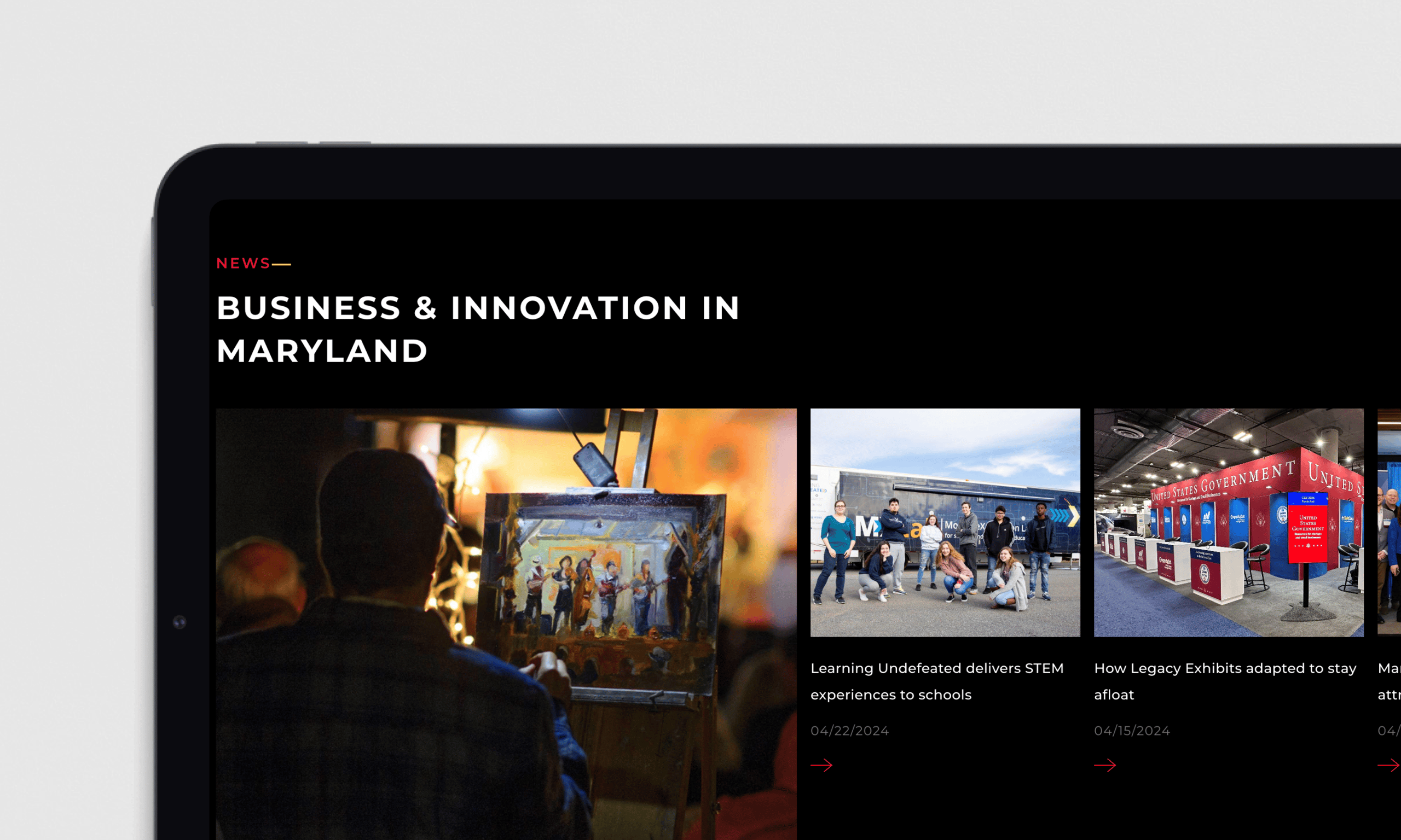 A digital news interface displays articles about business and innovation in Maryland, featuring stories about STEM education and Legacy Exhibits with accompanying thumbnail images.