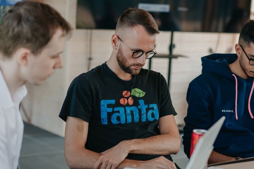 Three teammates gather around a table during a workshop.